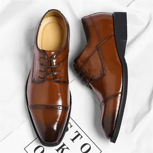 Bruine lederen zakelijke schoenen met krokodillenstructuur en brogue-neusdetails.
