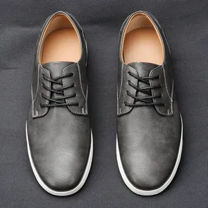 Scarpe casual da uomo in pelle grigia con suole bianche e cuciture a contrasto.