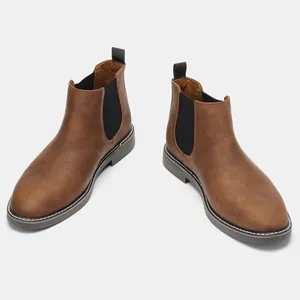 Detail view of classic brown men's Chelsea boots with vintage leather texture and elastic sides.