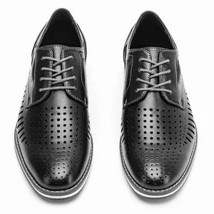Macro top-down view of black perforated breathable leather dress shoes for men.