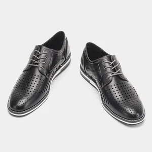 Close-up view of men's breathable black leather shoes with hollow perforated design