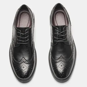 Top view showing exquisite wingtip brogue detailing on classic black leather derby shoes.