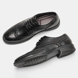 Detailed view of black leather brogue shoes with intricate wingtip carvings and rubber sole.