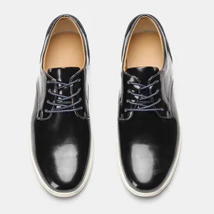 Vista superior de zapatos casuales de cuero negro brillante para hombre con suela blanca.