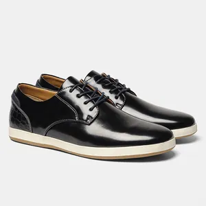 Vista lateral detallada de zapatos casuales de hombre en cuero negro brillante con cordones.