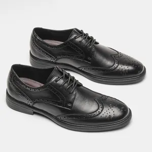 Detailed view of black leather Brogue shoes with wingtip carving and lace-up closure.