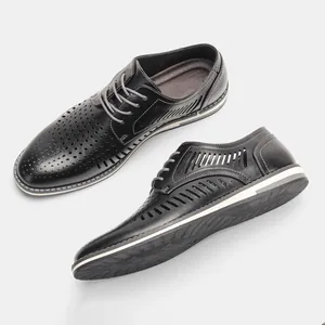 Close-up of breathable black hollow-out men's leather dress shoes with lace-up detail.