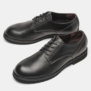 Vista macro della trama in pelle martellata nera premium di queste scarpe Derby da uomo.