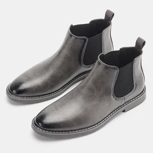 Dettaglio di stivali Chelsea grigi vintage da uomo con punta sfumata nera lucida.