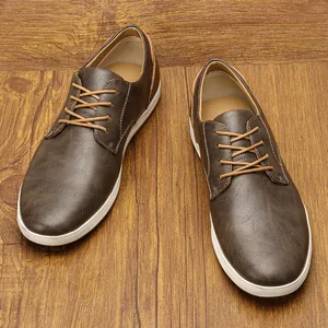 Vista detallada de zapatos casuales de cuero marrón para hombre sobre fondo madera