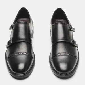 Top-down view of black leather double monk strap shoes with elegant brogue detailing