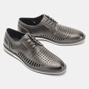 Detail of grey perforated leather men's shoes with a breathable hollowed-out design