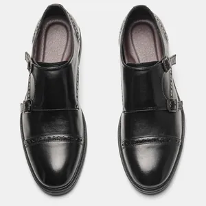Close-up of black leather monk strap shoes with elegant brogue perforated detailing