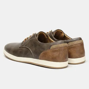 Vista posterior detallada de zapatos casuales de cuero marrón para hombre con suela blanca