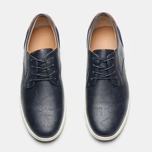 Vista superior de elegantes zapatos casuales de cuero azul marino para hombre con suelas blancas.