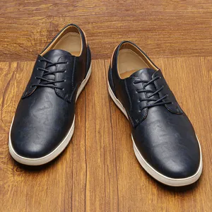 Vista superior detallada de zapatos casuales de cuero azul oscuro para hombre sobre madera
