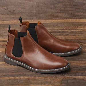 Dettaglio degli stivaletti Chelsea da uomo in pelle marrone vintage su legno scuro