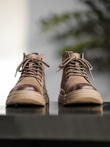 Detailed low-angle view of brown suede high-top Martin boots with round toe