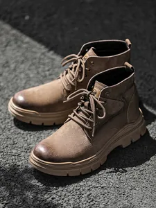 Detailed view of brown high-top outdoor work Martin boots with thick rubber soles