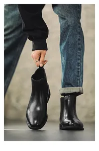 Detail van zwarte lederen Chelsea boots met een glanzende afwerking en een stevige rubberen zool.