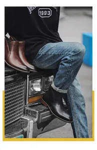 Detailed shot of stylish black and brown leather Chelsea boots for men in a vintage street setting