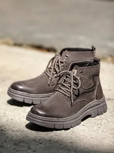 Close-up detail of brown suede outdoor work boots featuring a high-top lace-up design