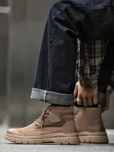 Detail shot of brown suede high-top men's work boots featuring a durable rubber sole
