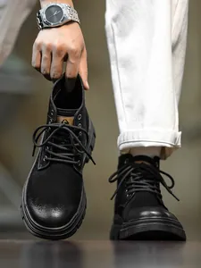 Detailed view of men's black high-top outdoor work boots with rugged non-slip soles