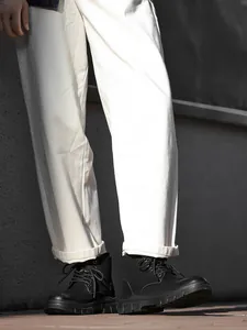 Close-up of black high-top Martin boots and work shoes for men in an outdoor setting