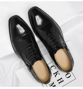 Detail von schwarzen Herren-Lederschuhen mit Brogue-Schnitzerei und Schnalle