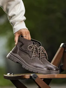 Detailed macro view of men's brown suede Martin boots featuring high-top lace-up design