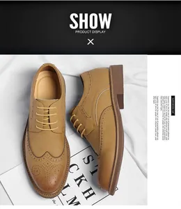 Detailed top view of tan men's brogue dress shoes with intricate wingtip carving.