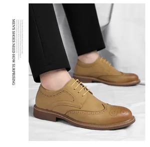 Detailed shot of men's tan brogue wingtip lace-up business leather shoes worn by a model