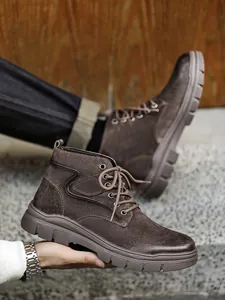 Close-up detail view of brown suede high-top outdoor Martin boots with rugged soles