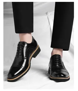 Close-up view of elegant black leather Oxford shoes with brogue detailing on a model.