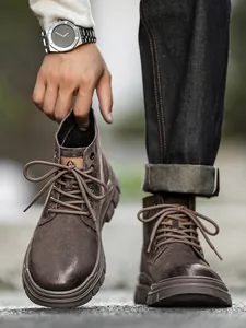 Detailed view of brown matte leather outdoor Martin boots with thick rubber soles