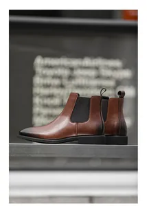 Zijaanzicht van vintage bruine leren Chelsea boots met gepolijste neus voor heren