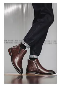 Macro view of brown leather Chelsea boots with side zipper and elegant stitching details