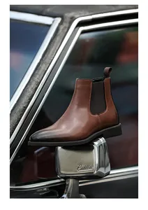 Detail van heren Chelsea-boots van gepolijst leer op de spiegel van een oldtimer