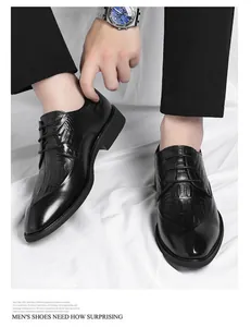 Detailed view of men's black formal elevator shoes with crocodile skin pattern texture