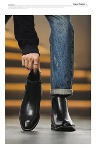 Close-up detail of stylish black leather Chelsea boots for men featuring a side zipper