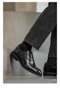 Πλαϊνή όψη από μαύρα δερμάτινα παπούτσια Brogue για άνδρες με κλασικές λεπτομέρειες