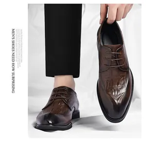 Detail view of brown men's elevator dress shoes with crocodile texture.