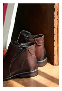 Detail view of men's brown leather Chelsea boots with side zipper and elastic panel