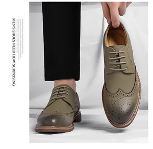 Detailed macro view of olive green men's business brogue shoes with wingtip patterns