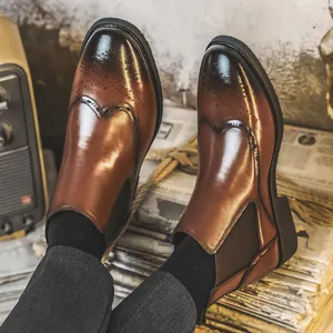 Elegante braune Chelsea-Boots aus Leder mit Brogue-Verzierung und elastischen Seitenteilen.