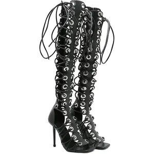 Detailweergave van zwarte modieuze stiletto veterlaarzen met metalen oogjes details