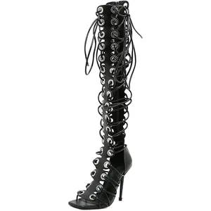 Zijaanzicht detail van zwarte kniehoge veter-stiletto sandalen met metalen oogjes.