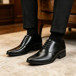 Detailed view of black formal leather oxford shoes with textured toe cap on a rug.