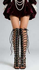 Detail van zwarte vetersandalen met naaldhakken, metalen oogjes en een open neus
